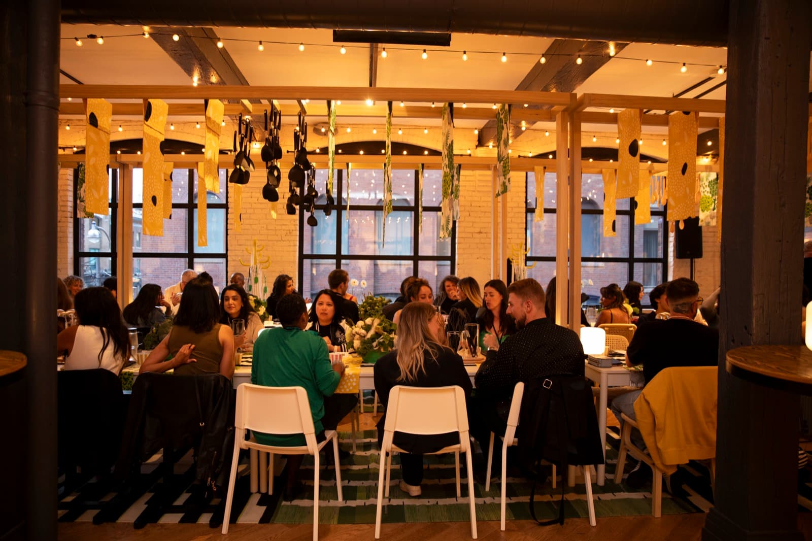 Communal dinner under string lights at Storys