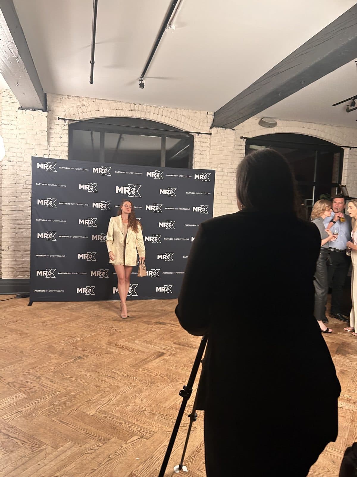 A guest posing in front of the MR. X step and repeat