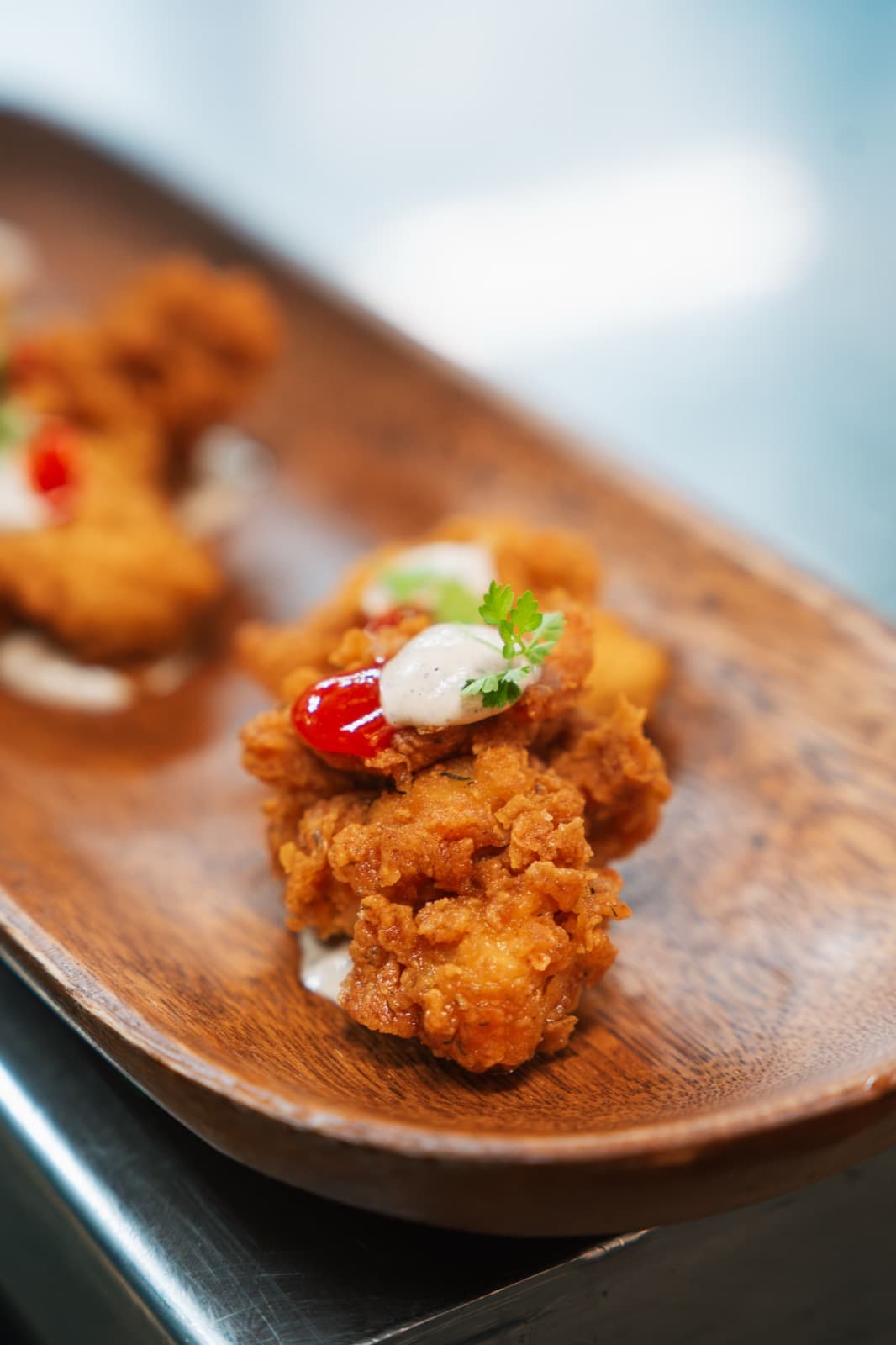 Crispy chicken canapes passed on a wooden board