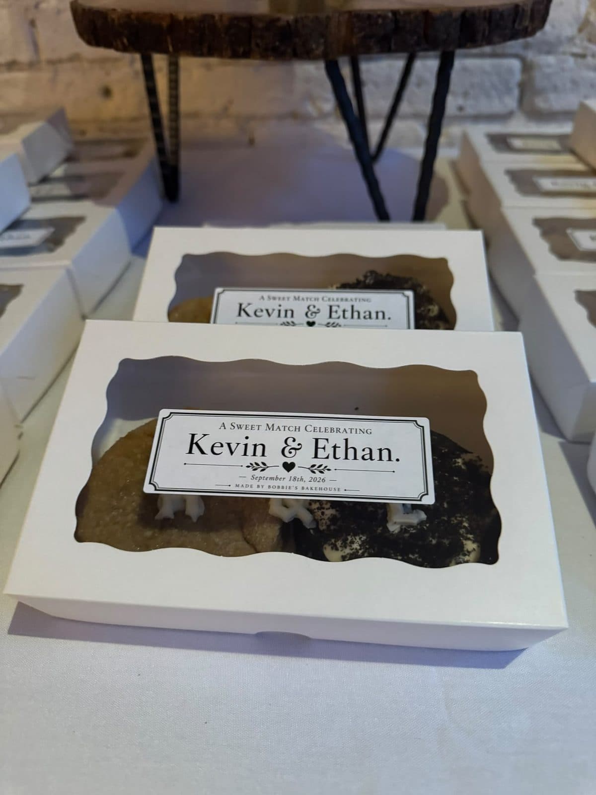 White favour boxes with window lids, each labelled A sweet match celebrating Kevin and Ethan, September 18th 2026.