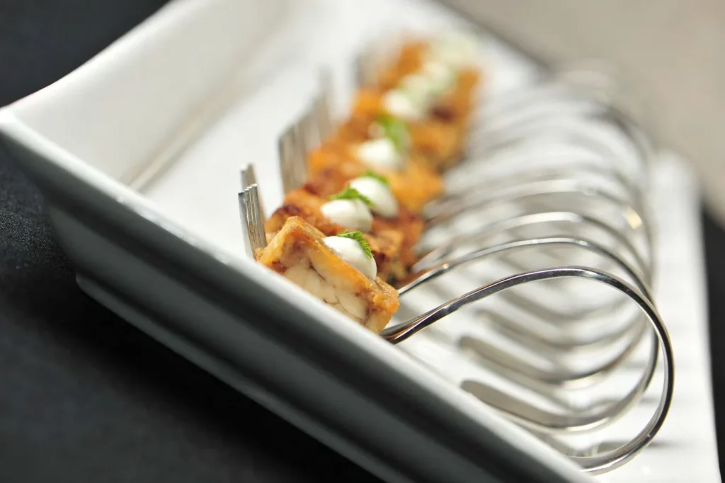 Bite-sized appetizers served on forks, suitable for catering at weddings, corporate events, and upscale gatherings.