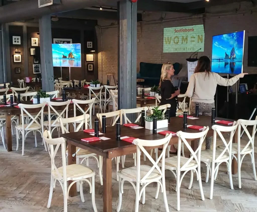 Corporate event setup with Scotiabank Women Initiative signage, modern seating, and presentation screens