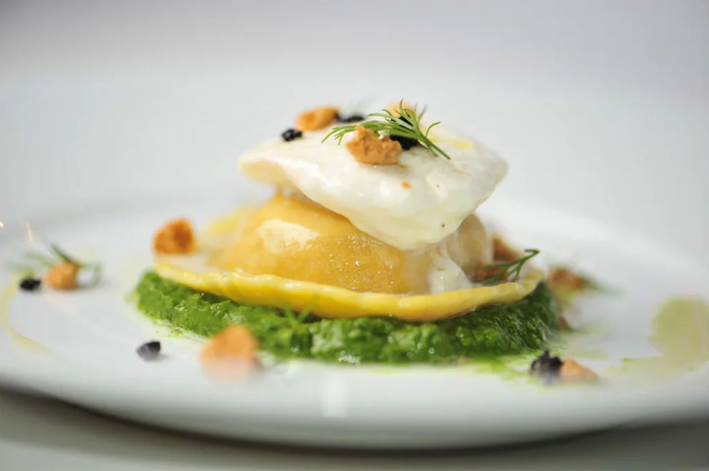 Exquisite gourmet plated dish with creamy sauce and herb garnish, ideal for luxury wedding or corporate event catering.