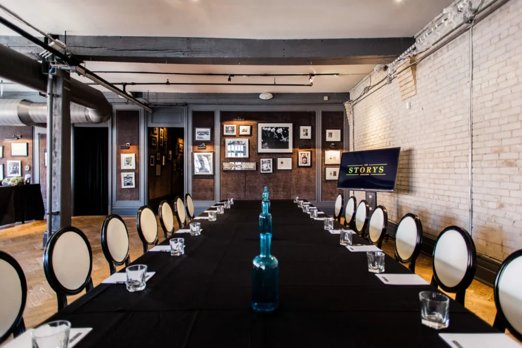 Industrial-chic boardroom setup with modern seating and a gallery wall, suitable for corporate meetings and private events.