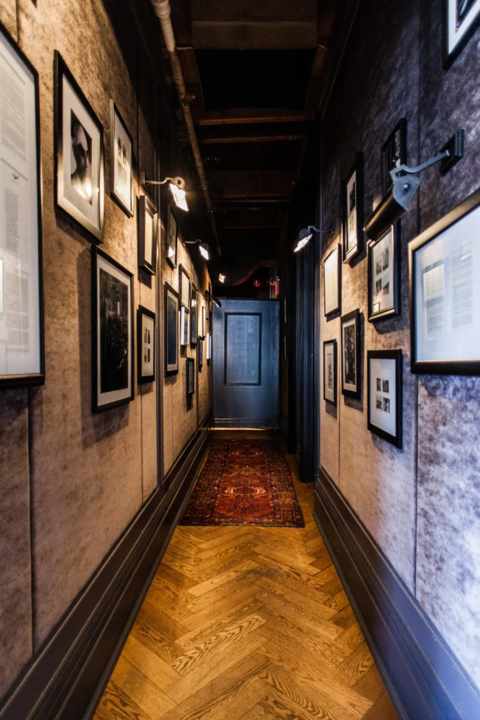 Narrow vintage-style hallway with framed artwork and gallery lighting, perfect for film shoots or adding character to boutique event venues.