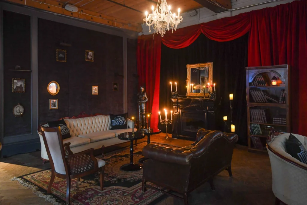 Vintage-themed event lounge with haunted mansion decor, chandeliers, candelabras, and antique furniture for film shoots and styled social gatherings