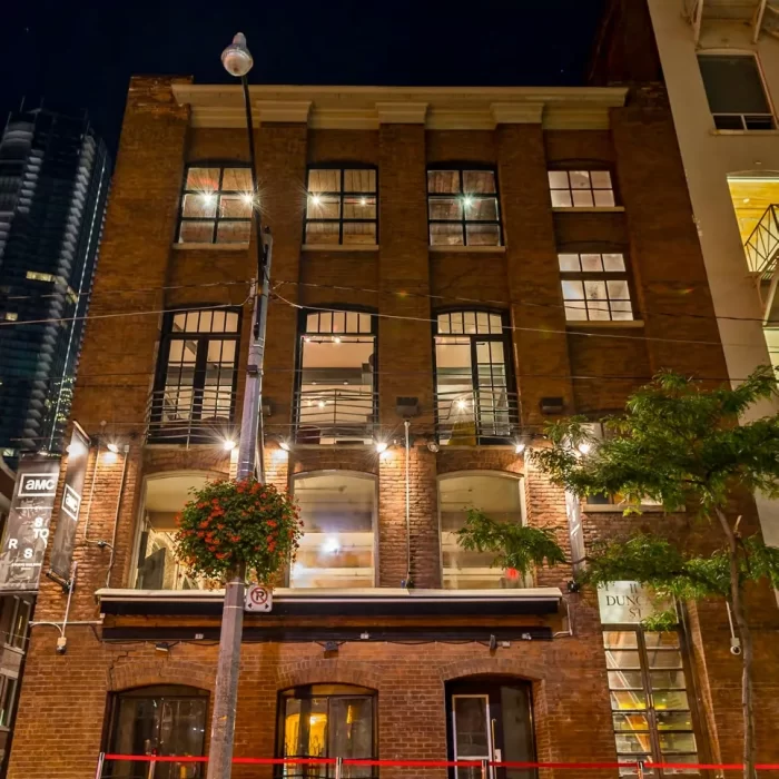 Illuminated brick event venue at night with red carpet entrance, ideal for upscale weddings, private parties, corporate events, and media productions.