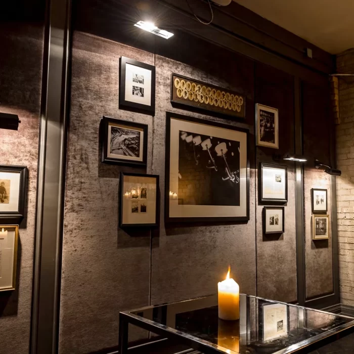 Moody candlelit lounge with framed vintage art, ideal for intimate gatherings and film photoshoots.
