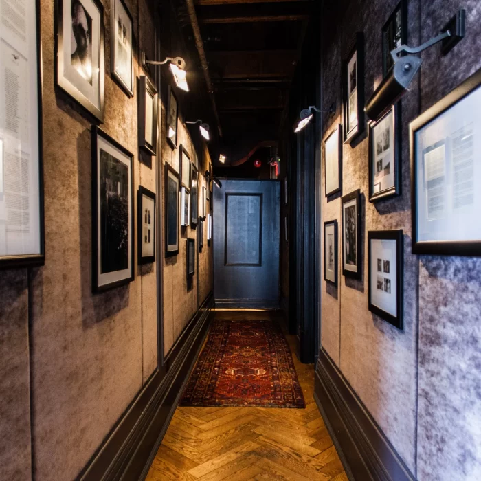 Narrow vintage-style hallway with framed artwork and gallery lighting, perfect for film shoots or adding character to boutique event venues.